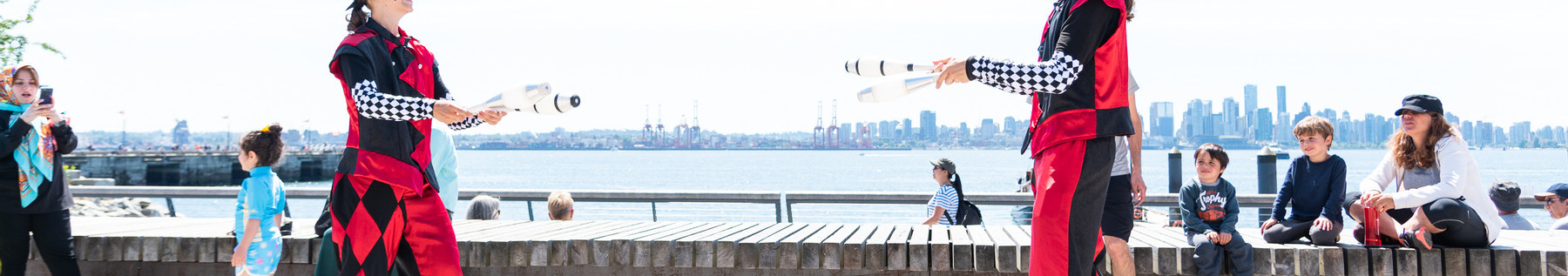 Jugglers performing at The Shipyards mega bench for families.